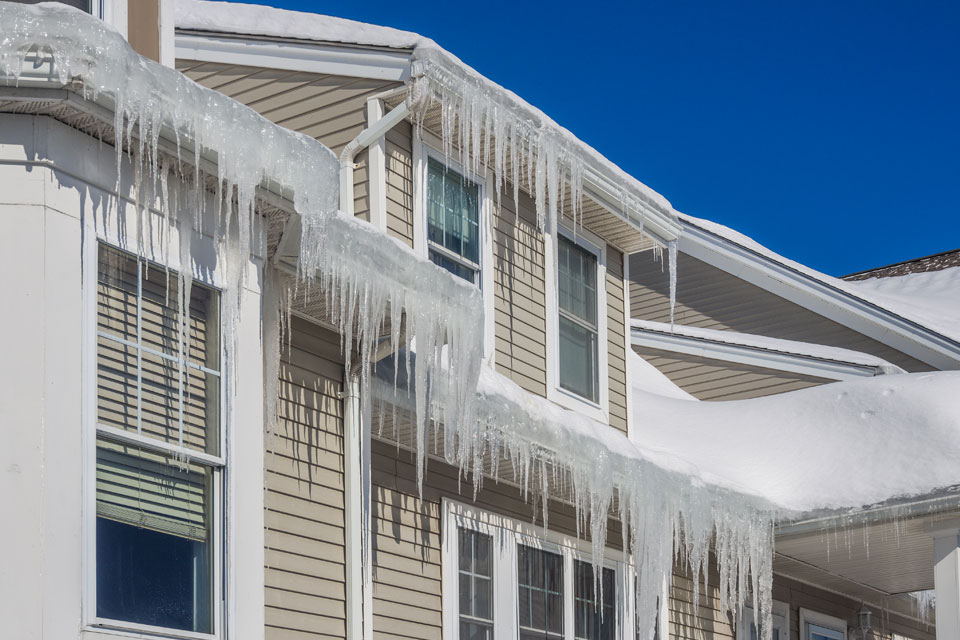 Photo of ice dams that have formed on the roof of a house