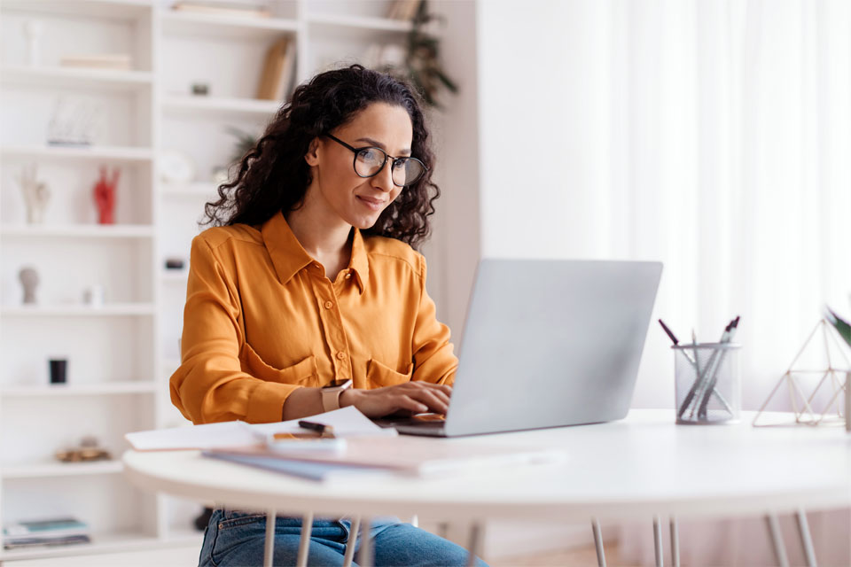 Image of a woman submitting an insurance claim on her computer